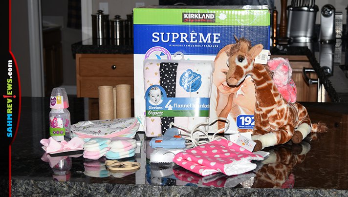 Make baby shower decorations functional by creating a diaper bike using diapers, receiving blankets, bottles and other items the mom-to-be will need. - SahmReviews.com