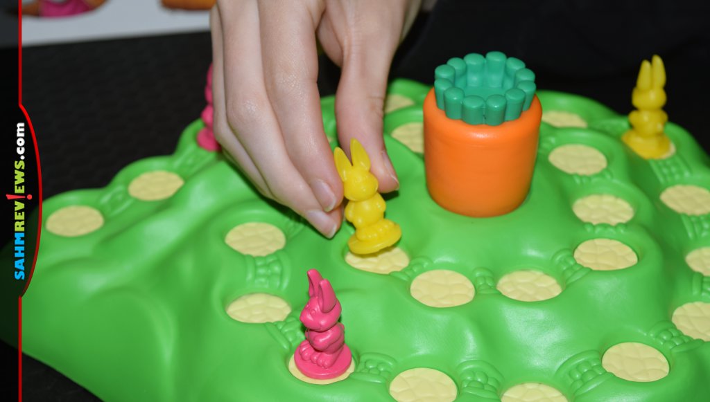 Funny Bunny Game - A woman's hand moving a yellow bunny on the board.