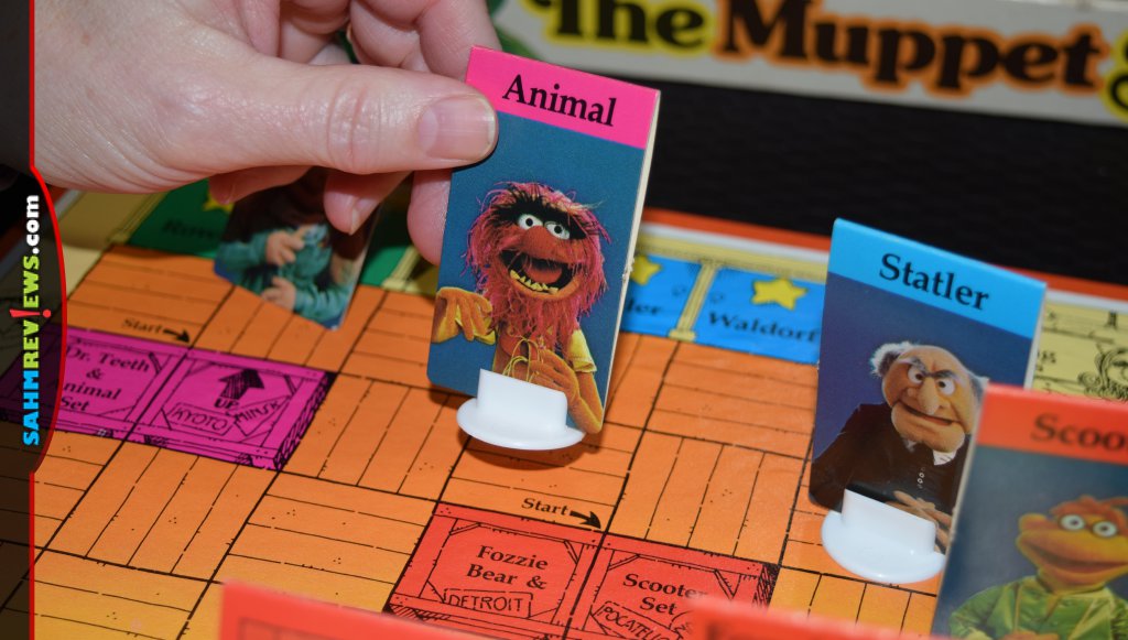 The Muppet Show Game - A Woman's hand moving a character piece (Animal).