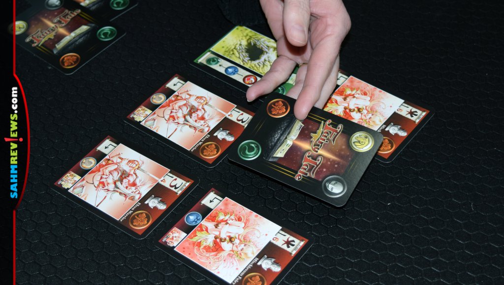 Fairy Tale Card Game - A woman's hand flipping over one of the cards