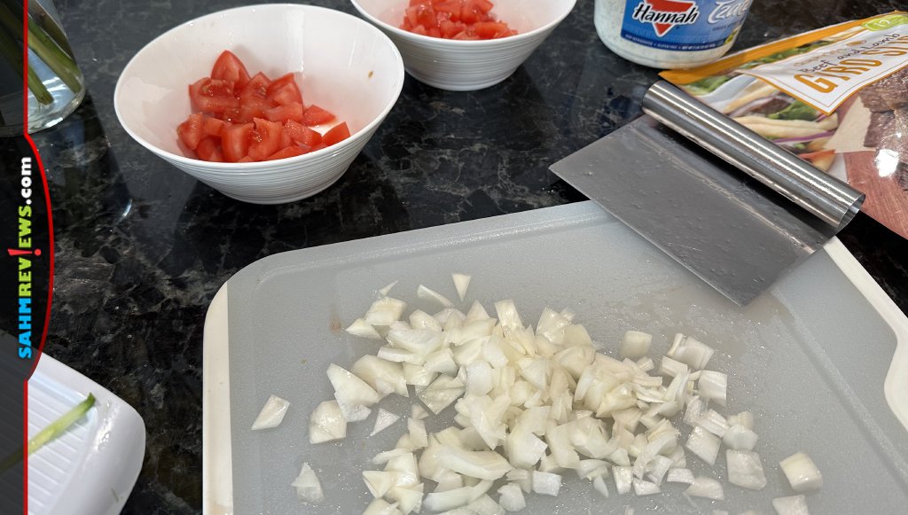 Cutting board with chopped onions and two bowls with diced tomatoes for gyro salad. - SahmReviews.com