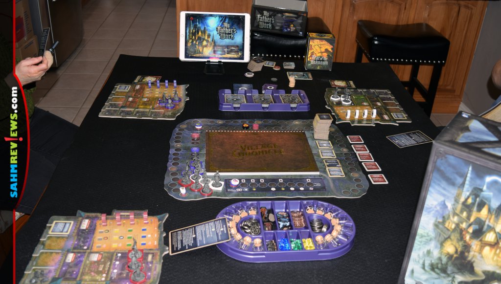 Setup of My Father's Work game including components, individual player boards, main board and iPad with app. - SahmReviews.com