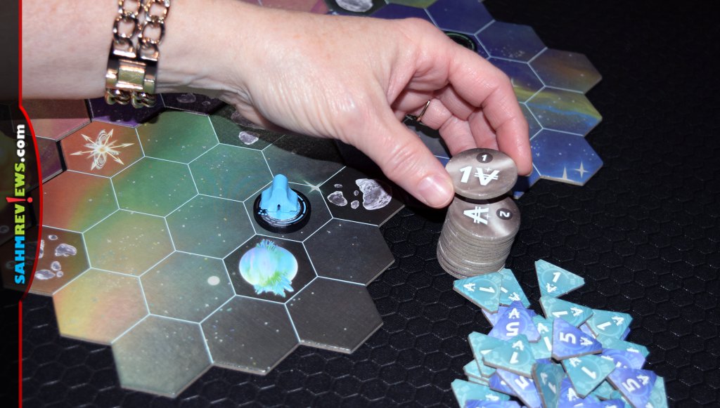 Wormholes game - Player collecting an exploration token for placing a wormhole next to a new planet