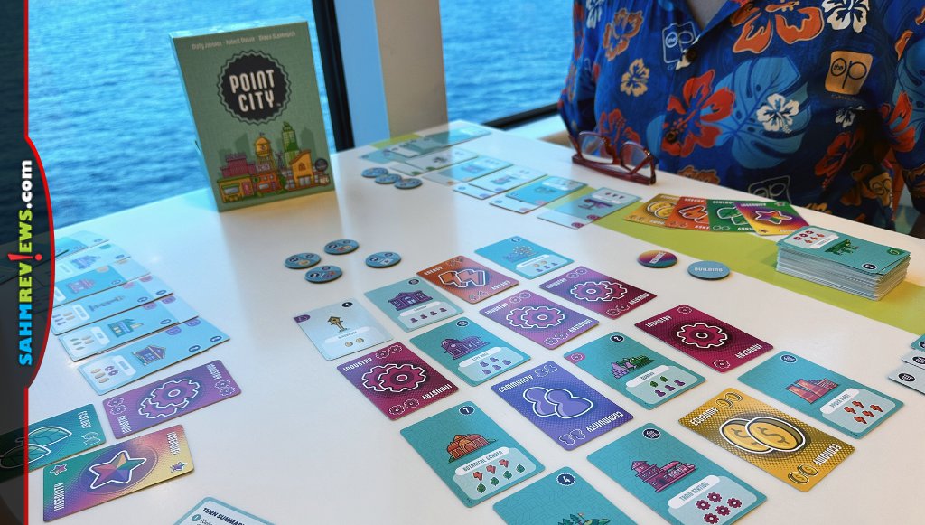 Setup of Point City involves a grid of cards, civic tokens and giving each player a wild resource card - SahmReviews.com