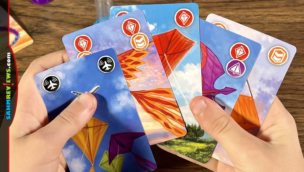 Players play kite cards and flip the corresponding sand timer in Kites cooperative game - SahmReviews.com